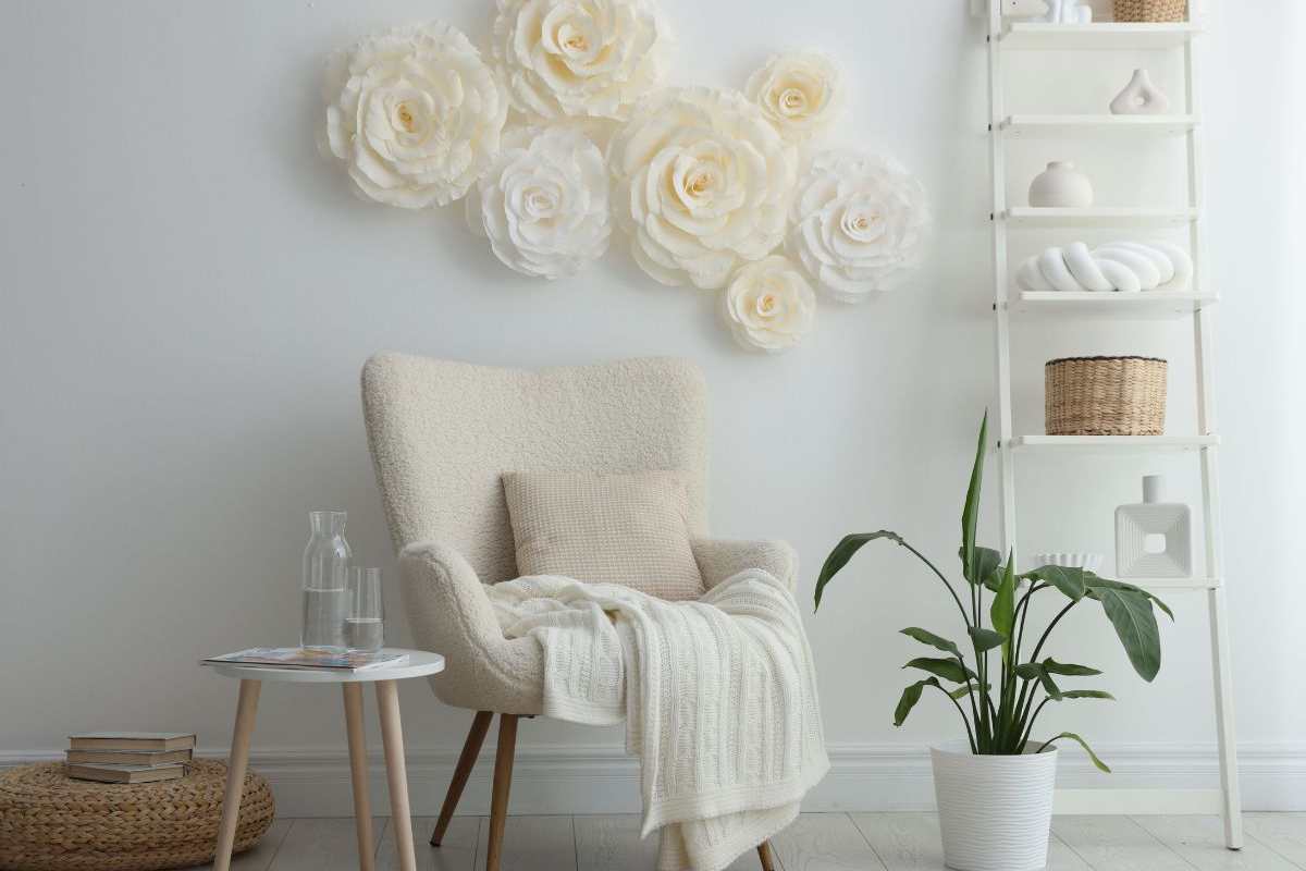 una parete decorata con fiori e una scaletta porta oggetti