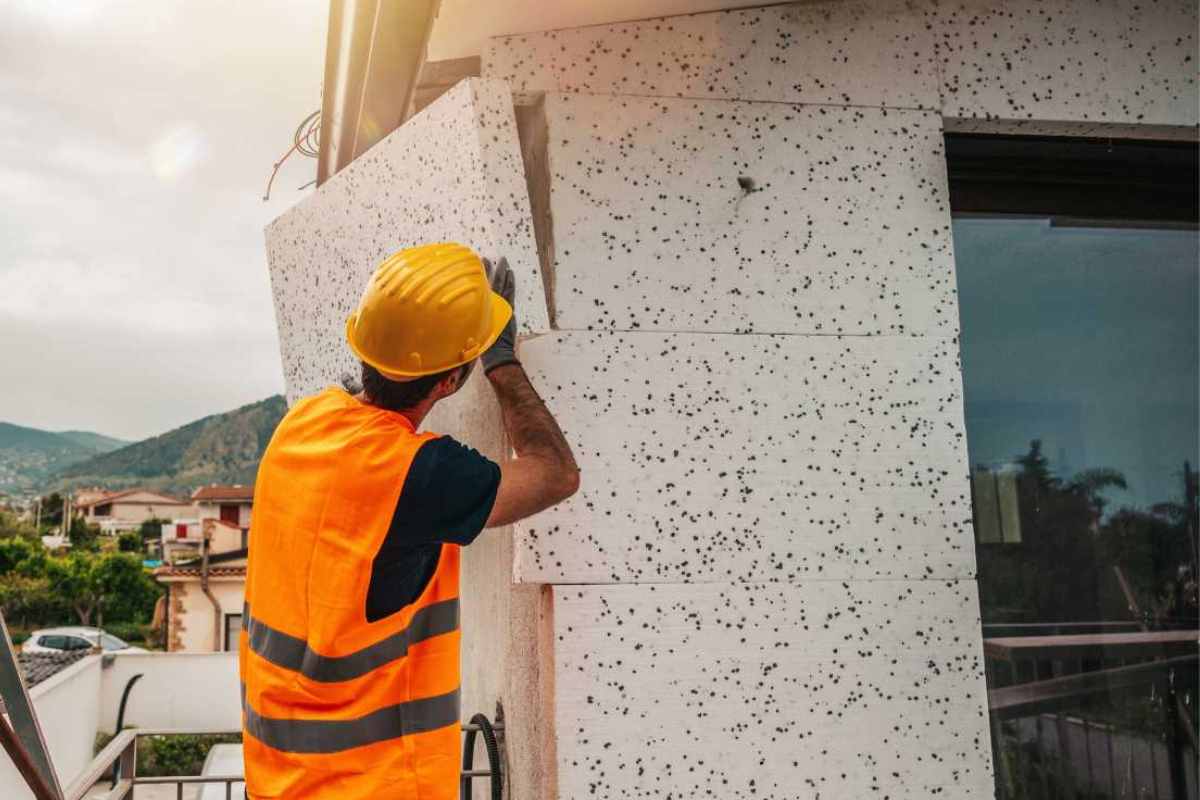 operaio che installa il cappotto termico esterno