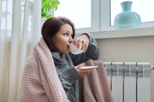 ragazza vicino al termosifone che beva