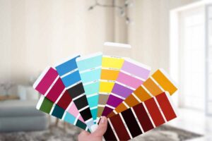 palette di colori in mano e soggiorno di casa come sfondo