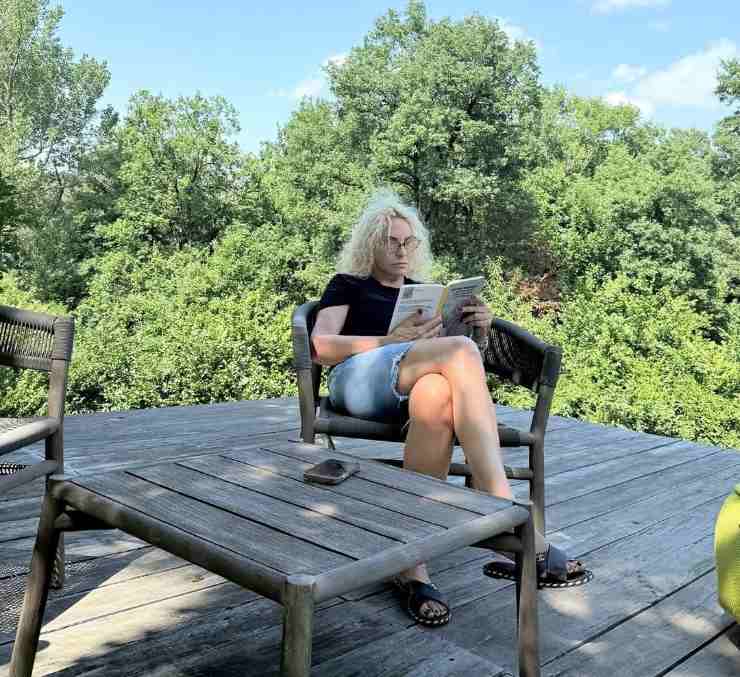 antonella clerici intenta a leggere un libro su un patio