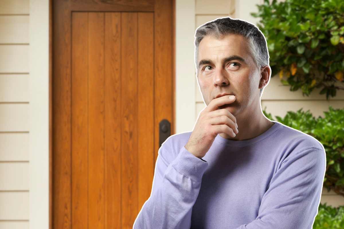 uomo pensieroso e porta di casa