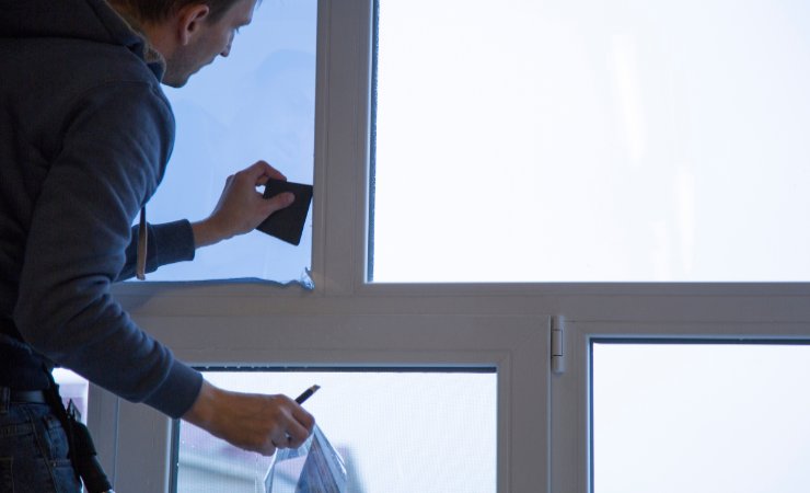 uomo che applica pellicola adesiva alla finestra