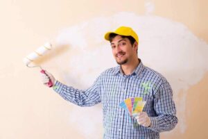 uomo con rullo e palette di. colori in mano