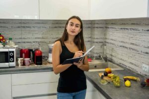 donna con agenda in mano in cucina