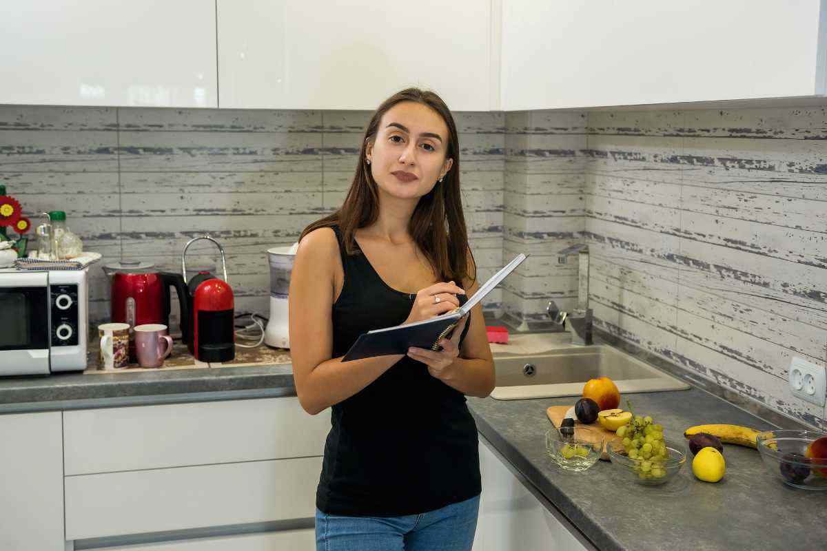 donna con agenda in mano in cucina