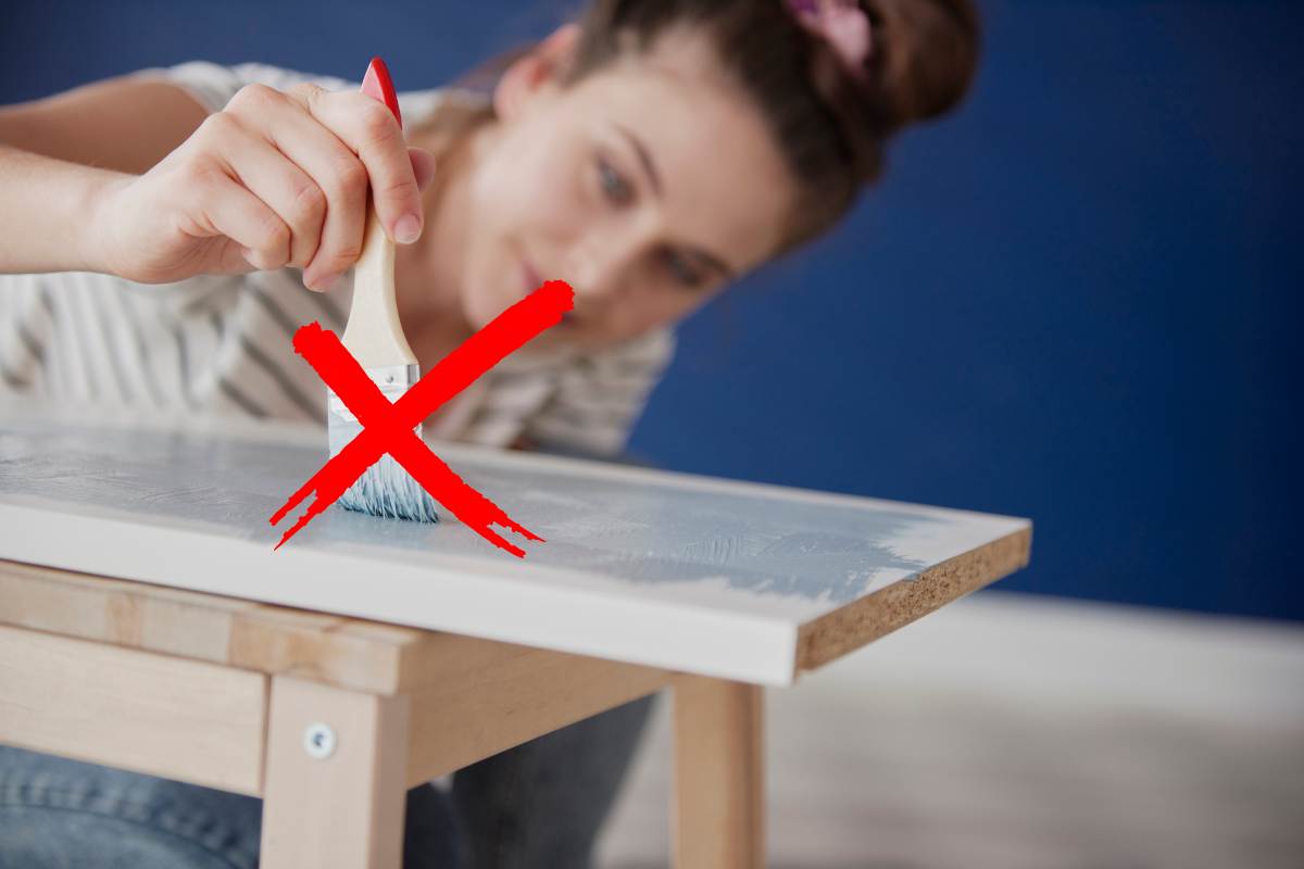 ragazza che vernicia asse di legno